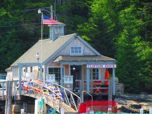 A house on the dock, which is transformed into a shop, with a bridge in front of it. If you like it, movers Clifton NJ can make sure you see it daily.