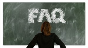 Woman looking at board with FAQ on it.