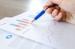 A close-up of a chart and a person holding a pen.