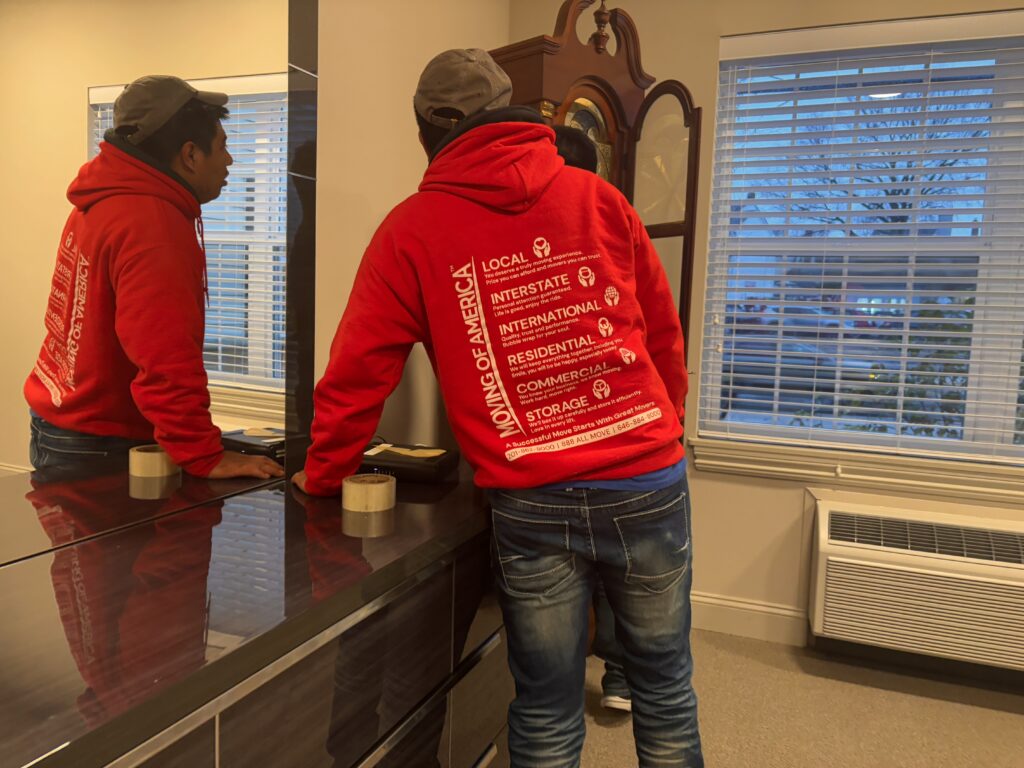 Professional movers preparing to navigate tight hallways during an apartment move in New Jersey.