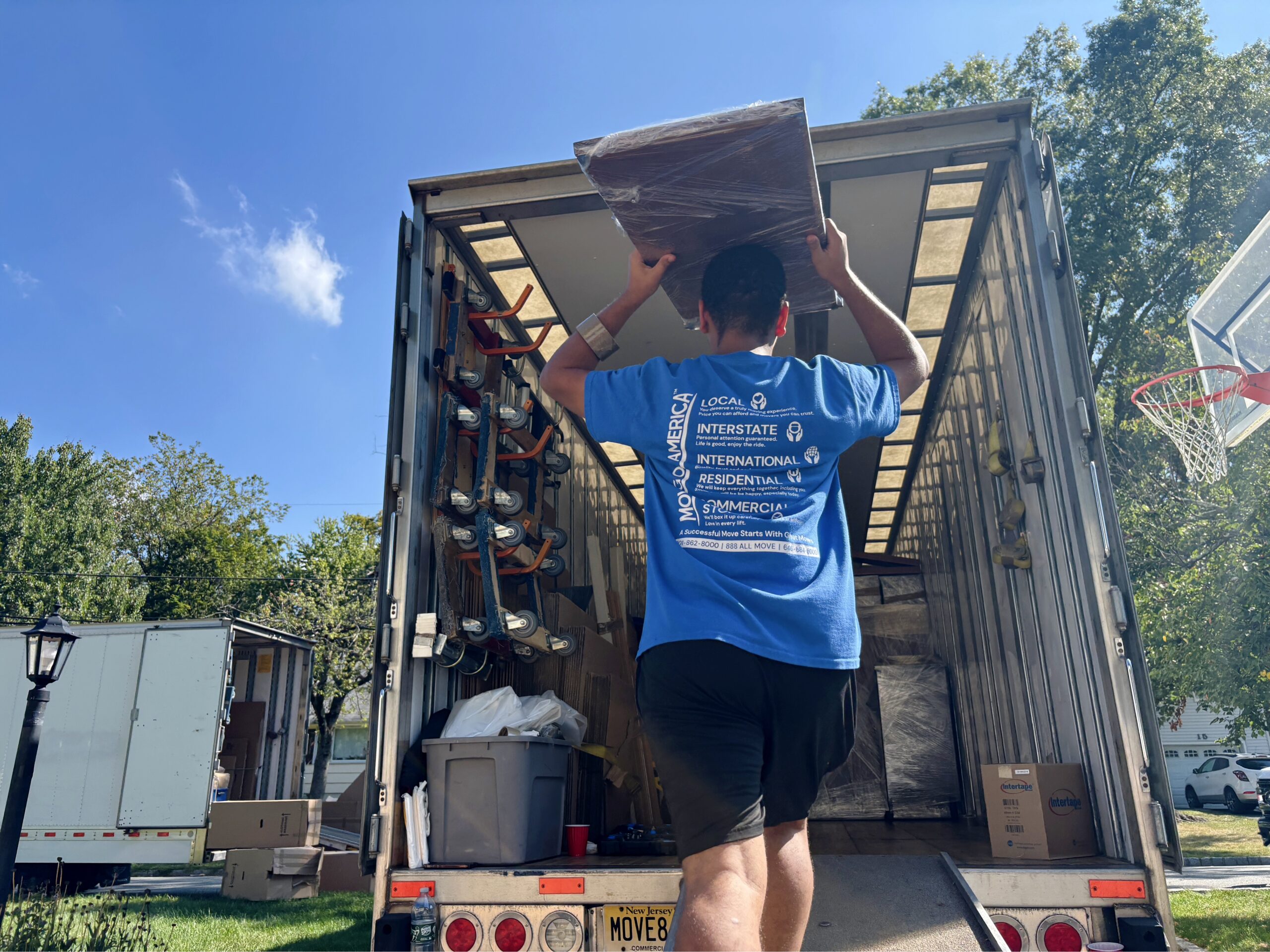 Professional movers handling a military relocation, packing and securing household items for an active-duty service member’s PCS move.