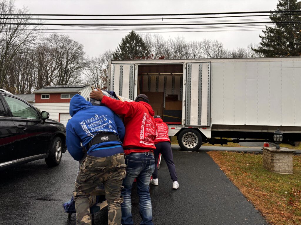 Professional movers supporting a senior citizen during a move.